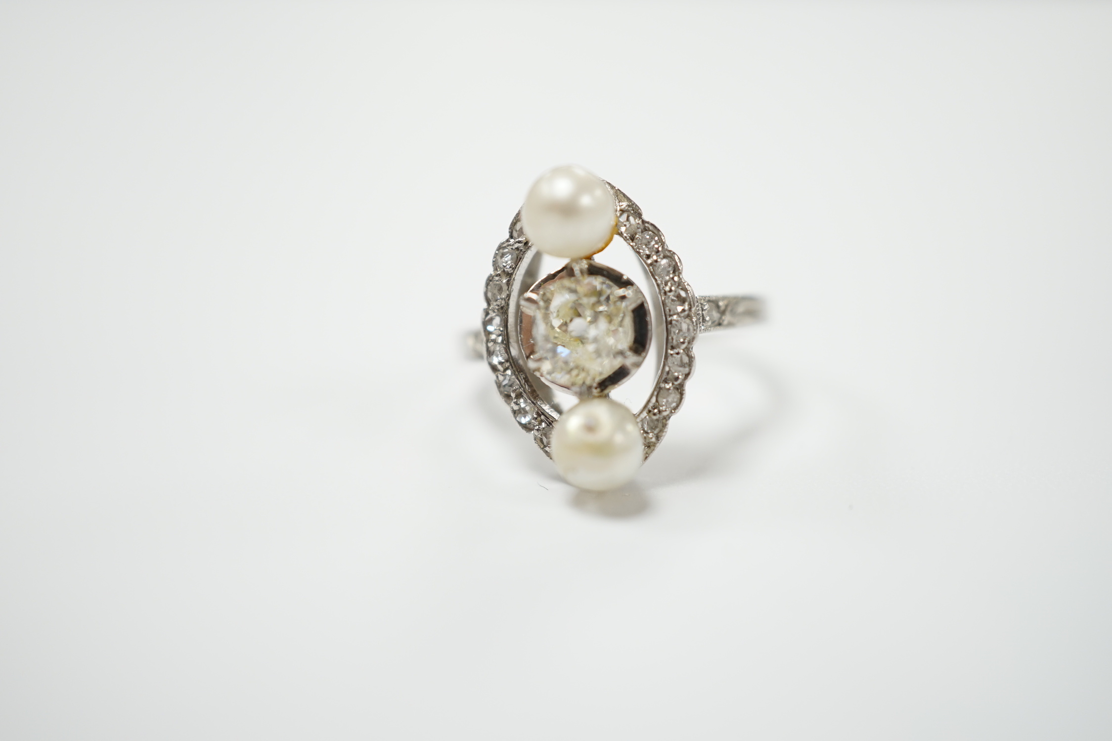 A white metal single stone diamond and two stone cultured pearl set elliptical shaped ring, size F, gross weight 4.3 grams.